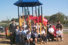 [Photo 3:  HUD volunteers and students at their new playground.] 