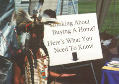 [Photo 1: HUD sign pointing to information on HUD homebuying programs.]