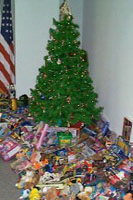 [Photo 2: Christmas tree with many many toys piled beneath.]
