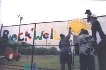 [Photo 3: More volunteers putting up pieces of the Art Wall.]
