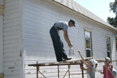 [Photo 2: World Changers volunteers paint the Ellingsons' house.]