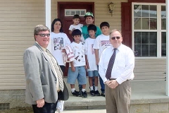 [Photo 2: The Delgado family in front of their new home.]