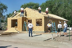 [Photo 1: Habitat volunteers build Tracy Elkins' new home.]