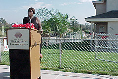 [Photo 2: A Youthbuild participant speaking at a podium.]