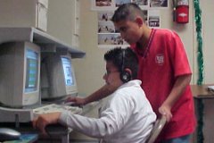 [Photo 2: Children work on the refurbished computers.]