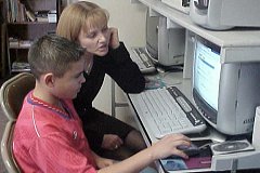 [Photo 3: A student being tutored in the computer center.]