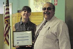 [Photo: Debbie Grove holding a certificate presented by Miguel C. Rincon, Jr.]