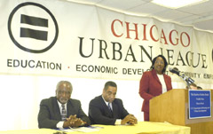 [Photo 1: Carolyn Peoples at the podium with the Congressmen seated to her right]