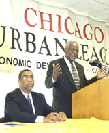 [Photo 2: Congressman Rush listening to Congressman Davis at the podium]
