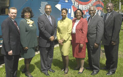 [Photo 3: Dignitaries standing along side of the bus]