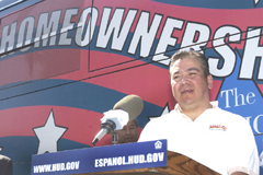 [Photo 2: New homeowner Roberto Zavala speaking to the audience]