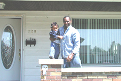 [Photo: Mr. Fernando and his daughter, Avis, on the porch of their new home]