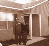 [Photo: The Johnson's outside their new home]