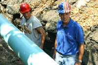 [Photo 2: The governor and other volunteers placing the pipeline]