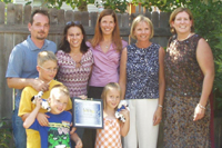 [Photo 2: The Baxters joining with their housing partners in the back yard of their new home]