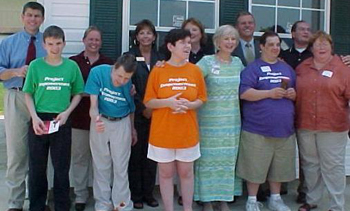 [Photo 3: The four new homeowners with the people who helped turned dreams into reality]