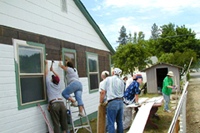 [Photo 2: The work crew cutting siding that will be installed on the Dollar Home]
