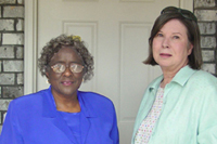[Photo 1: Director Lola May (left) and new homeowner Mary Talbott]