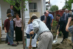 [Photo 1: Ceremonial tree planting in front of Waltz's new home.] 