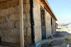 [Photo 1: Exterior shot of the house reveals bales of straw inset in the walls.]