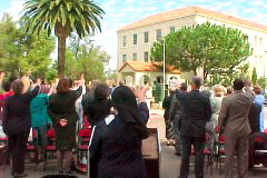 [Photo 2: Residents and staff extending their arms in blessing]
