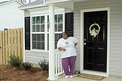 [Photo 2: Harriet in front of her new home]