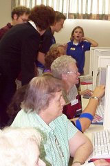 [Photo 3: Students pair with residents to help them learn various computer skills]