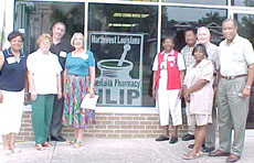 [Photo 2:  NLIP volunteers and administrator standing in front of the pharmacy]