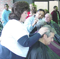 [Photo 2: Volunteer hairdressers giving free haircuts]