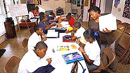 [Photo 2: Coordinator Gwen Taylor (right) helping students]