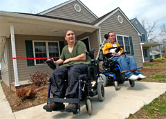 [Photo: The Keens on wheelchair in front of their new home]