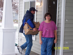 [Photo 2: Betty Jo Stucks in front of her new home on move-in day]