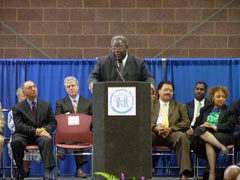 [Photo 2: Acy Suber at the podium]