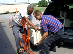 [Photo 4: People unloading some of the equipment]
