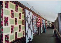 [Photo 3: Many quilts on display]