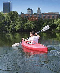 [Photo: A boy in canoe exploring the water of downtown Lynchburg]