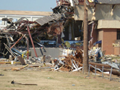 [Photo 2: Section of the school with the walls collapsed and the roof ripped off]