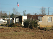 [Photo 7: U.S. flag over the damaged property]