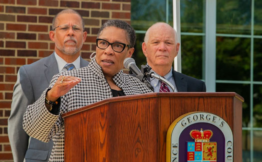 [Secretary Marcia L. Fudge speaks at Build Back Better event with U.S. Representative Anthony Brown (MD-04) (left) and U.S. Senator Ben Cardin (right) in Prince George's County, Maryland.]