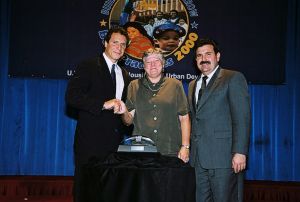 Photo of Lynne Cooper (c) receiving award from Secretary Cuomo & Deputy Secretary Ramirez