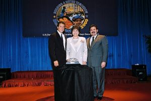 Photo of Rebecca Flannagan (c) receiving award from Secretary Cuomo & Deputy Secretary Ramirez