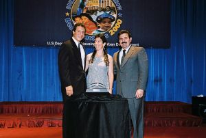 Photo of Debby Weinstein receiving award from Secretary Cuomo & Deputy Secretary Ramirez