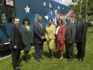 [Photo 3:  Dignitaries standing along side of the bus]