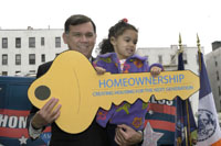 [Photo 1: Secretary Martinez and a little girl holding a yellow Homeownership key]