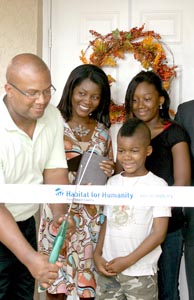 [Photo 1: Army Veteran Michael Phillips, with wife Yolanda and their children, received keys to the home they help build with Habitat for Humanity and HUD Neighborhood Stabilization Program funds]