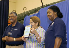 [Photo of the lucky lady who won the grand prize with event announcers standing at her side.]