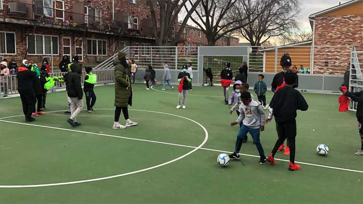[Oakridge Neighborhood residents and middle school students break-in the new mini-pitch and strut their soccer skills.]