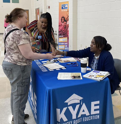 [A local tenant visits a community information table.]