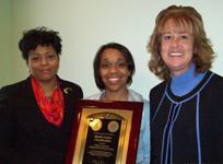 [Photo: The center director displays the plaque for Model Center Classification.]