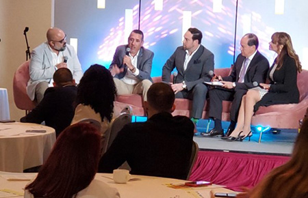 [HUD San Juan Field Office Director Efrain Maldonado (second from right) and HUD appraiser Yoel Sanchez (second from left) discussing condo financing and providing guidance at the National Association of Real Estate Professionals.]